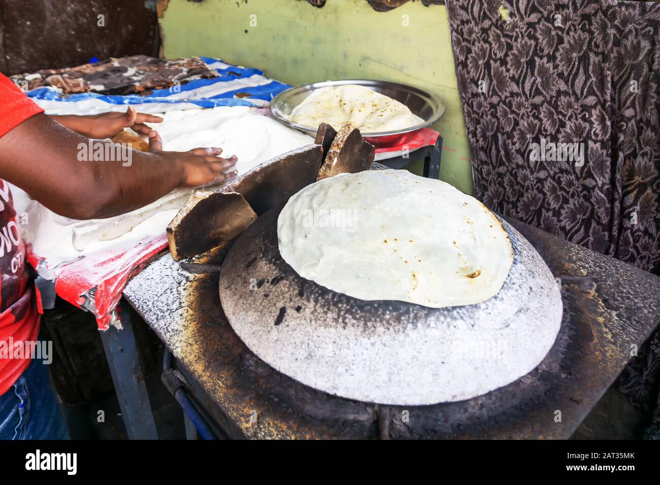 Man Preparing and cooking chapati roti at Chandni Chowk in Old Delhi India Stock Photo