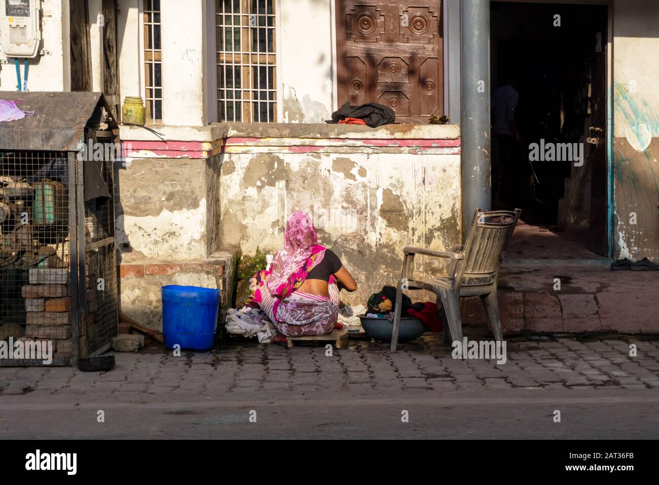 New Delhi, India - March 03, 2018: Unidentified Indian woman washing clothes outside her house. Stock Photo
