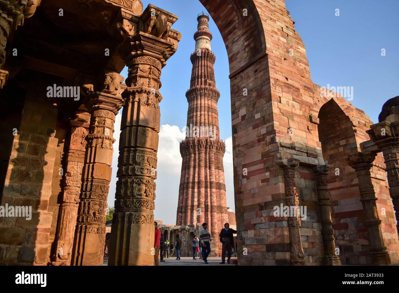 Visitors walk around the historic Qutub Minar in Delhi.Qutub Minar, a UNESCO World Heritage Site, is the tallest minaret in India. The Qutub Minar was built in the early 13th century a few kilometers south of Delhi. Stock Photo