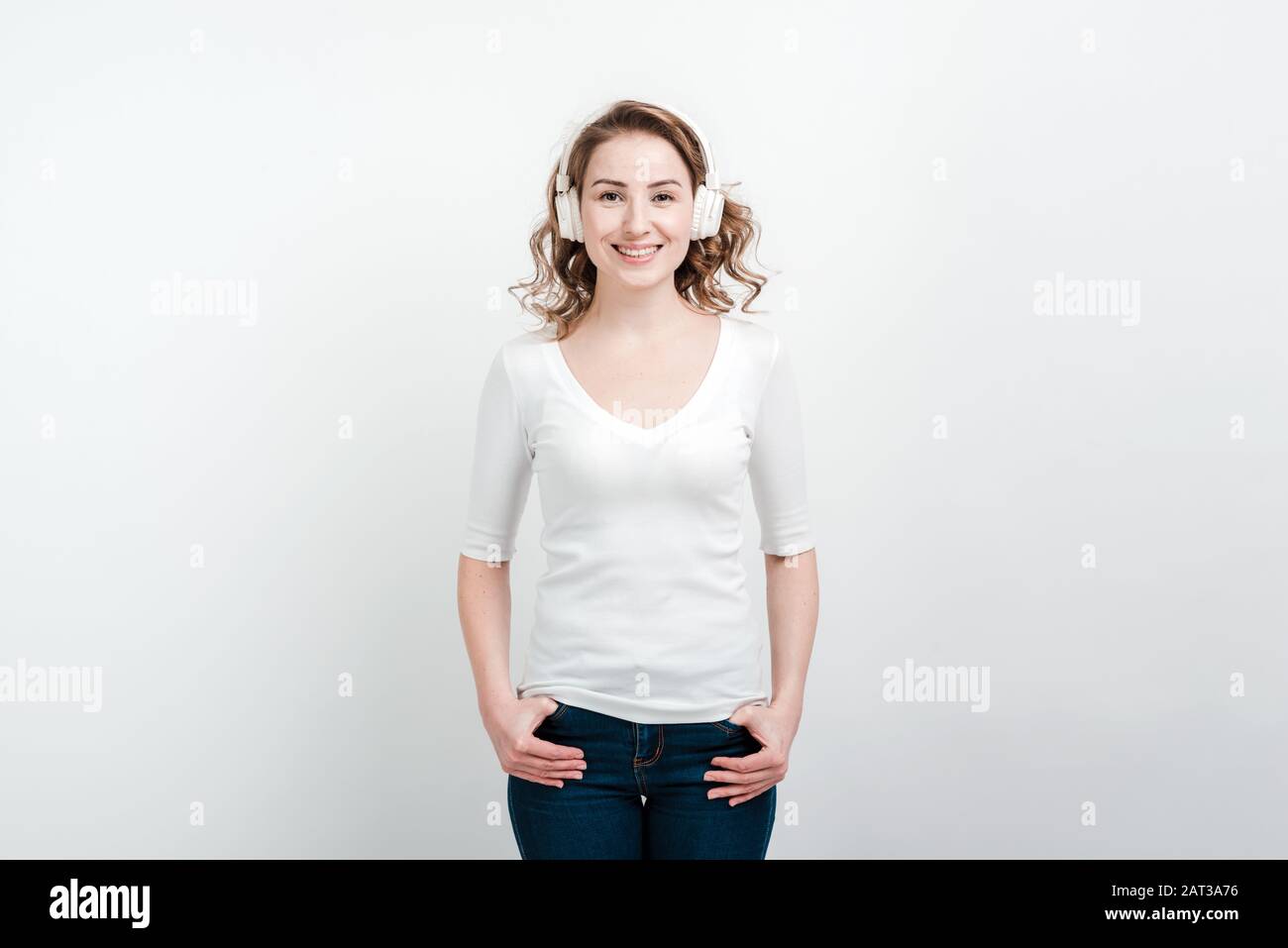 Smiling girl posing in headphones. Isolated on a white backgroun Stock Photo