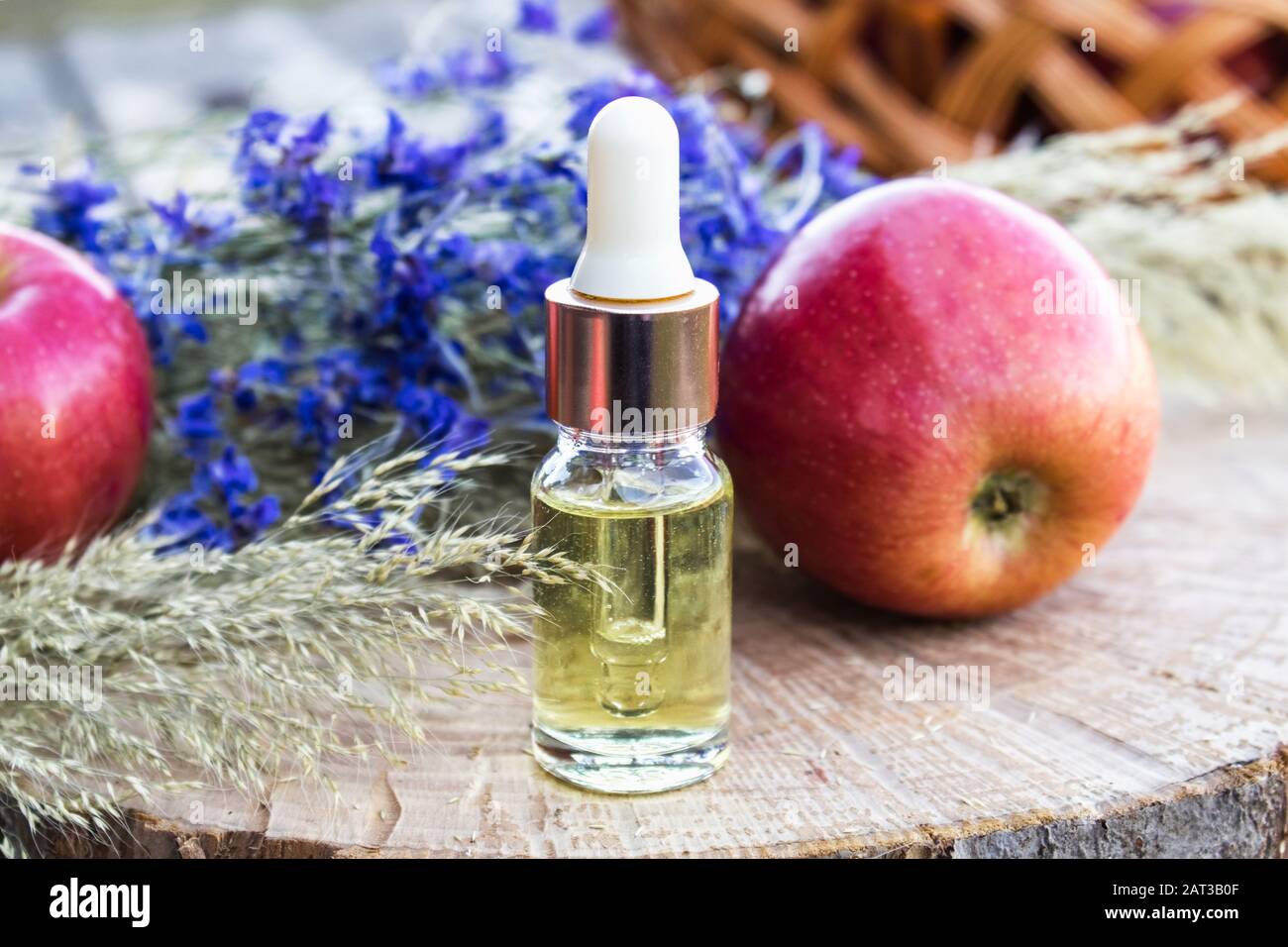 Bottle of apple essential oil and fresh apples on a wooden table. Essential  oil is used to fill lamps, perfumes and in cosmetics. Close-up Stock Photo  - Alamy