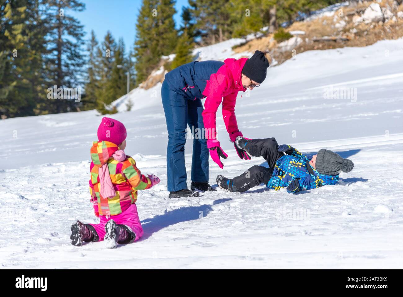 Family play on the snow.  Mother throws children into the snow. concept of boosting immunity in winter season Stock Photo