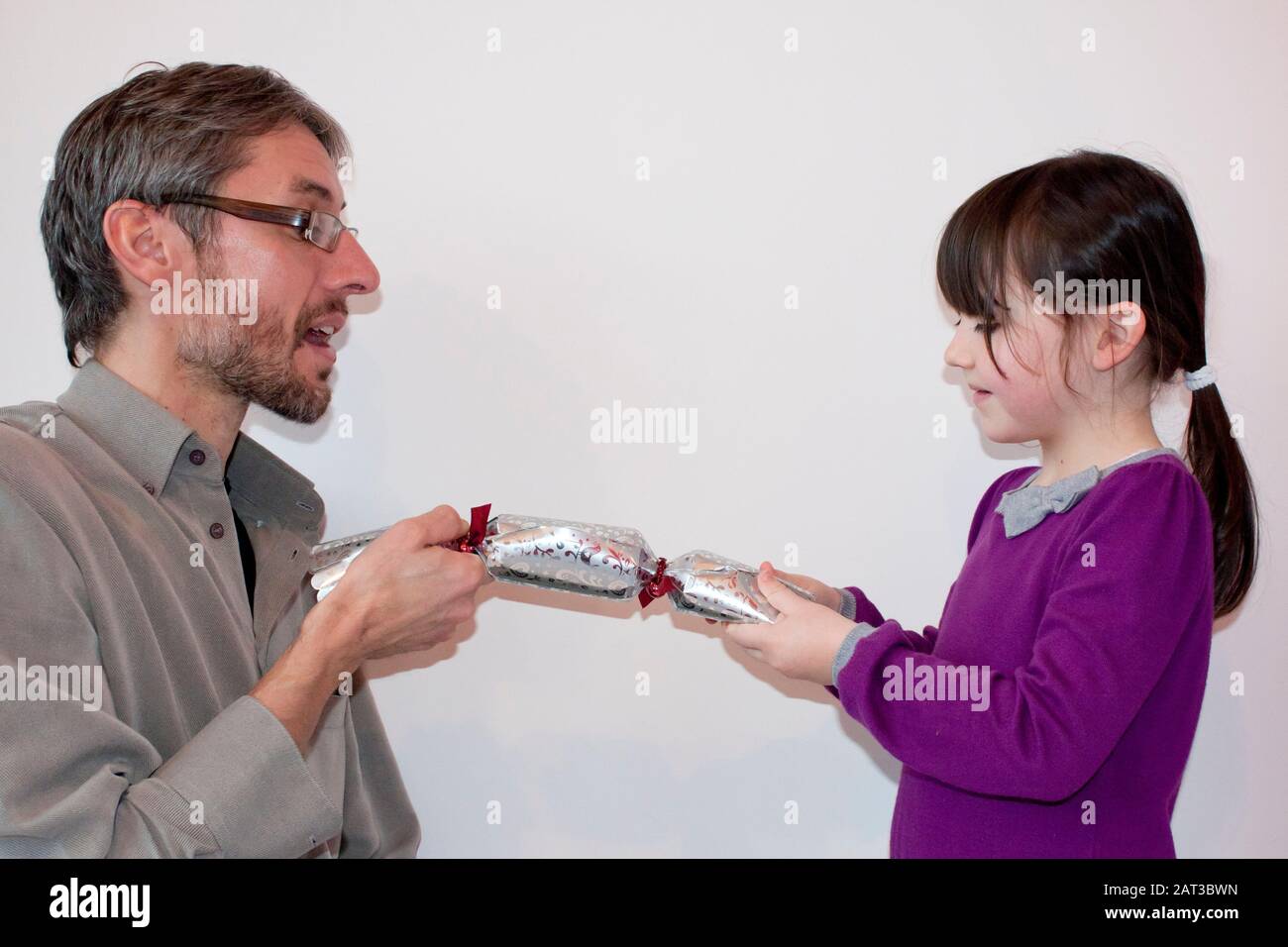 Father and daughter pulling Christmas cracker Stock Photo