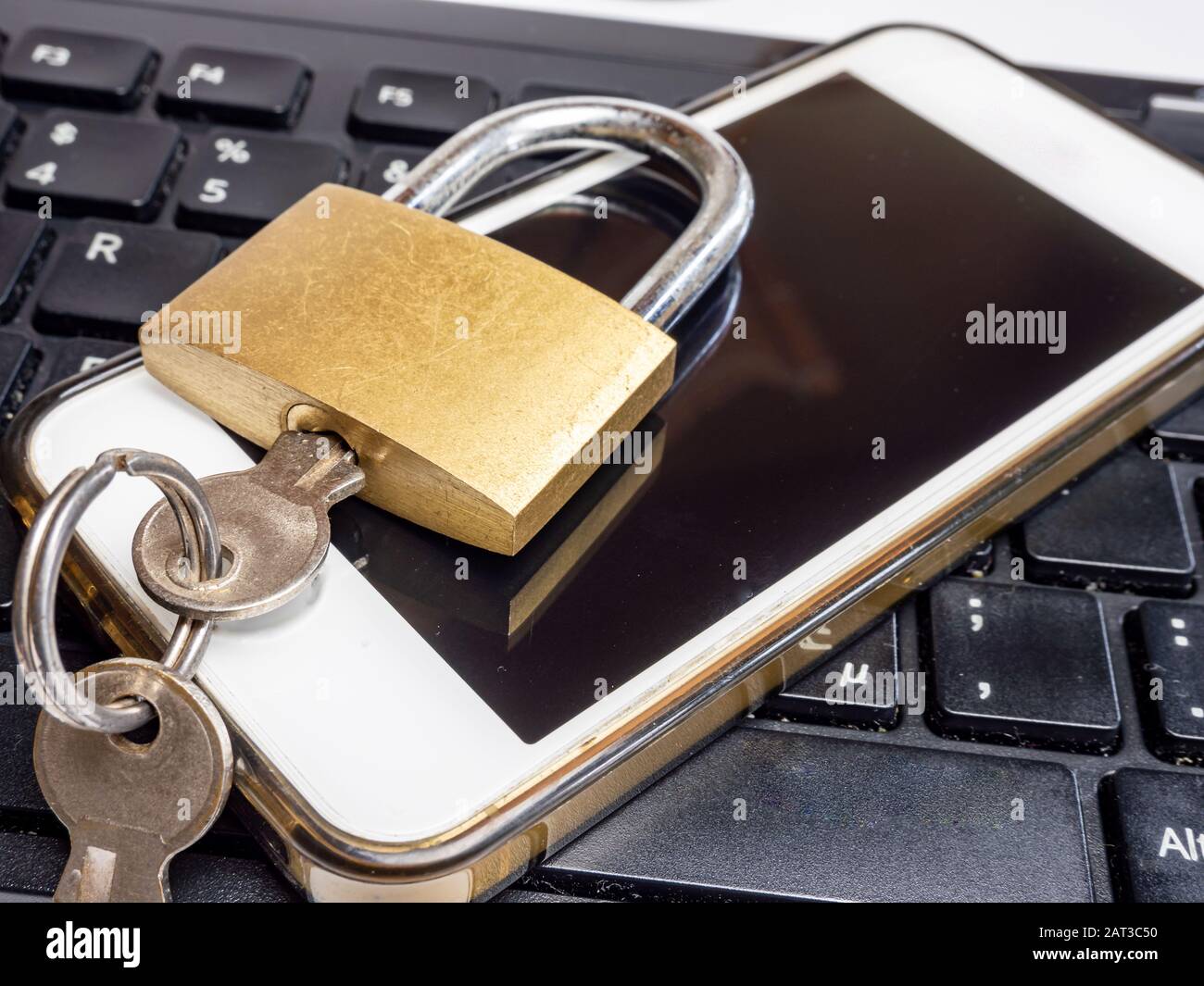 Padlock on keyboard with smartphone Stock Photo