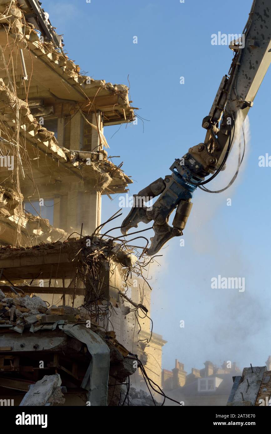 A building being demolished using a high reach arm fitted with shears Stock Photo