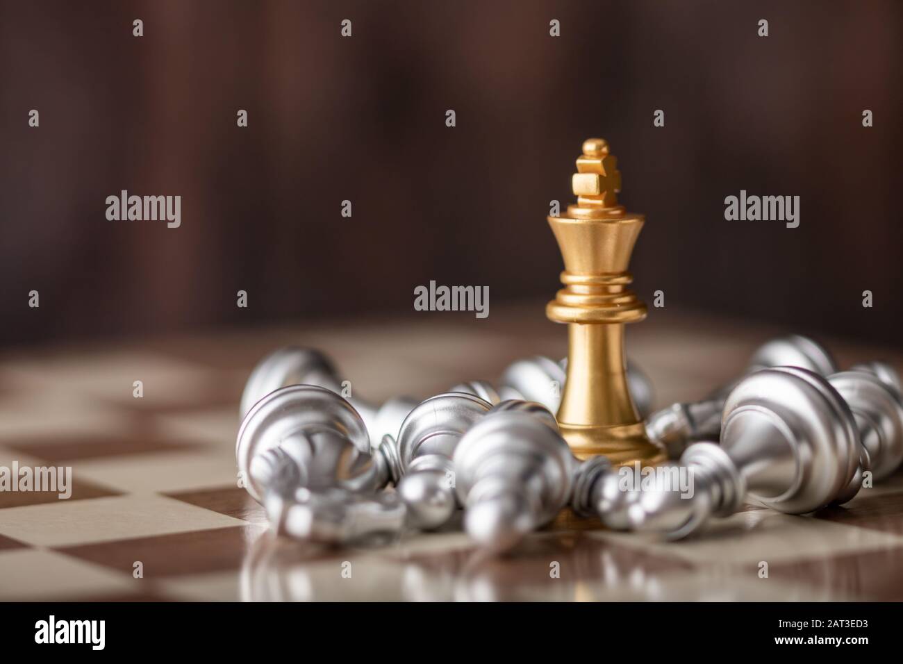 gold king standing in the midst of falling chess on board Stock Photo