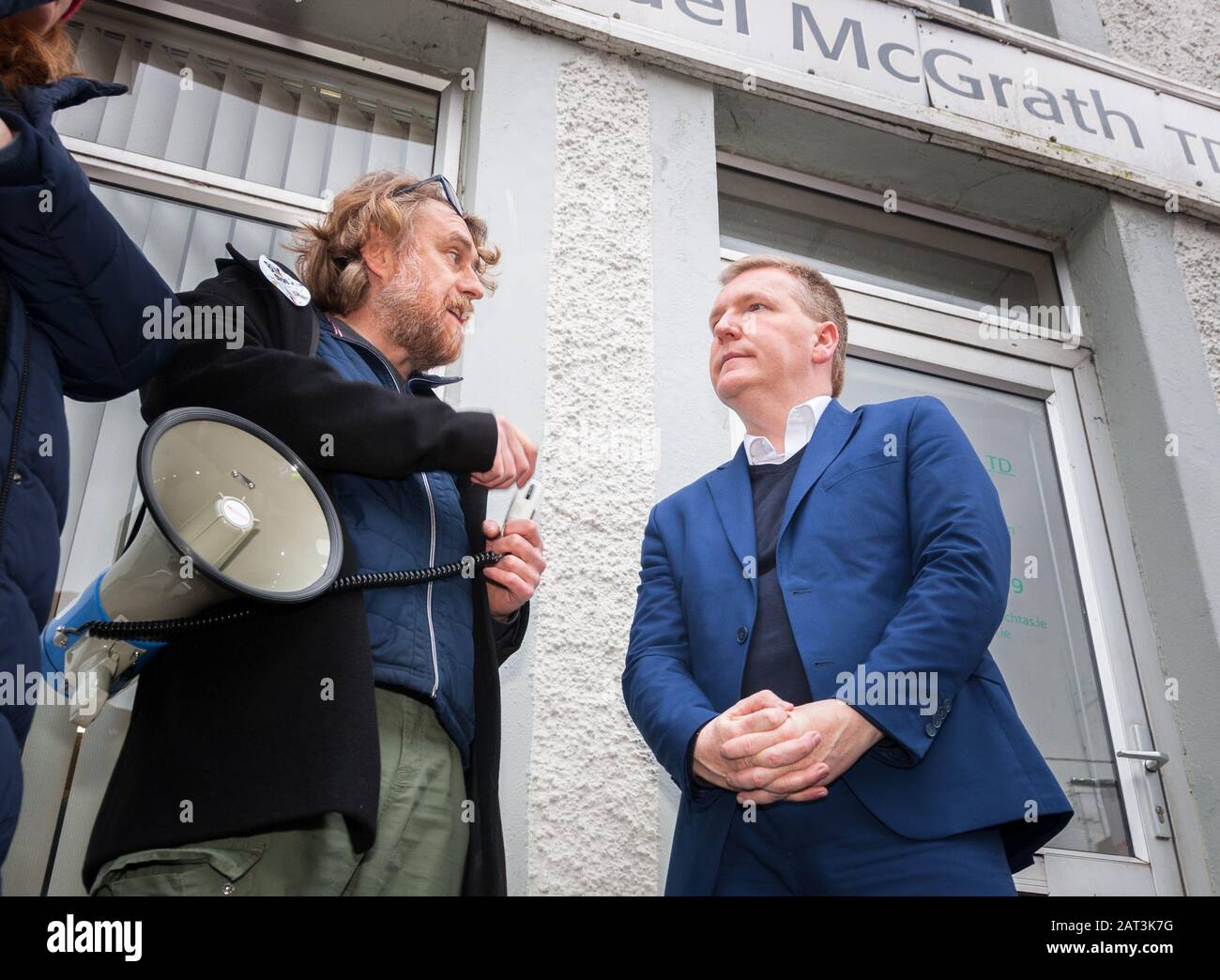 Carrigaline, Cork, Ireland. 30th January, 2020. John Bowman of the childcare and parents protest group speaking with Deputy Michael McGrath T.D. Fianna Fáil Spokesperson on Finance outside his constituency office where they are seeking support for increased funding for childcare providers in Carrigaline, Co. Cork, Ireland. -Credit; David Creedon / Alamy Live News Stock Photo