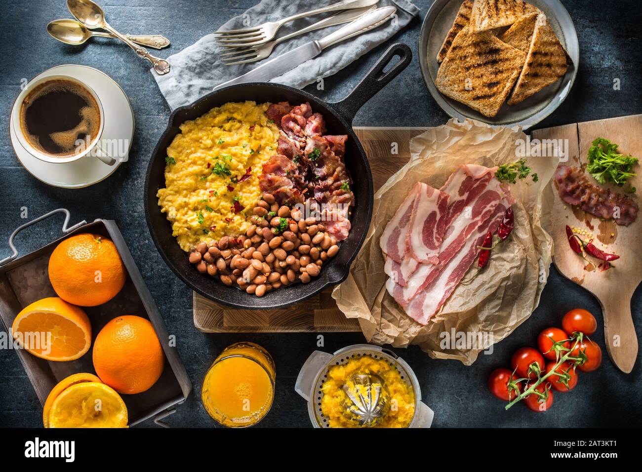Full table of english breakfast. Scrambled eggs grilled bacon beans toast bread orange juice and