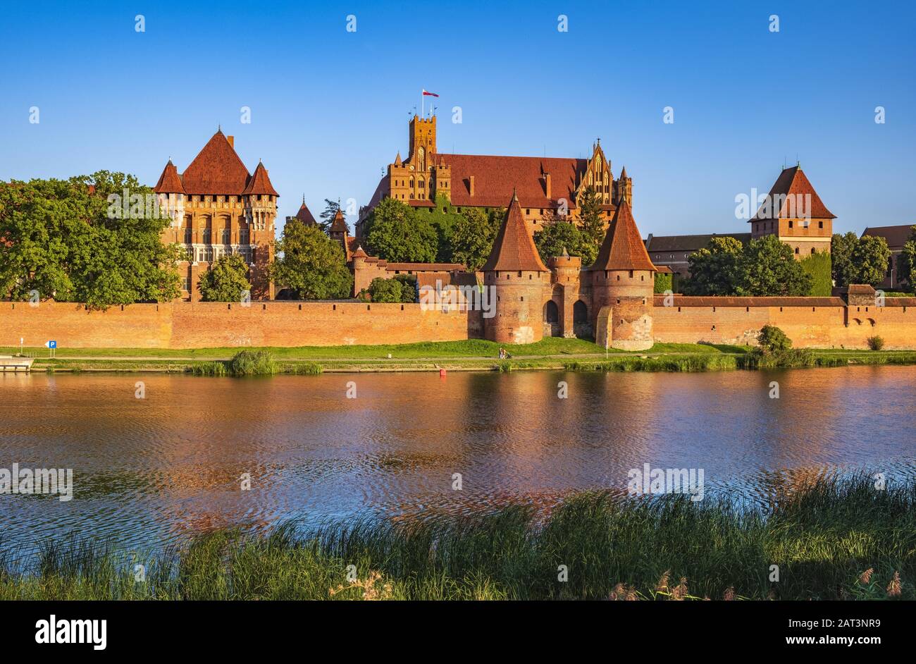 Malbork, Pomerania / Poland - 2019/08/24: Panoramic view of the defense walls and towers of the Medieval Teutonic Order Castle in Malbork, Poland from across the Nogat river Stock Photo