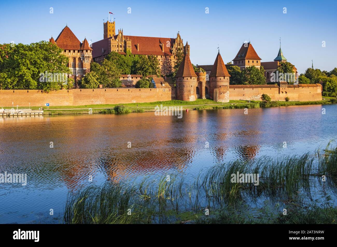 Malbork, Pomerania / Poland - 2019/08/24: Panoramic view of the defense walls and towers of the Medieval Teutonic Order Castle in Malbork, Poland from across the Nogat river Stock Photo