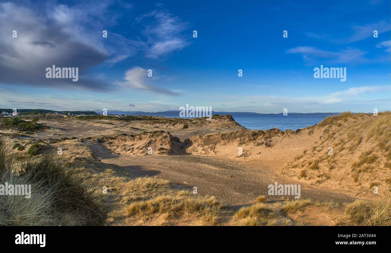 FINDHORN BEACH MORAY SCOTLAND SAND DUNES COVERED BY MARRAM GRASS THE VILLAGE HOUSES IN THE DISTANCE Stock Photo