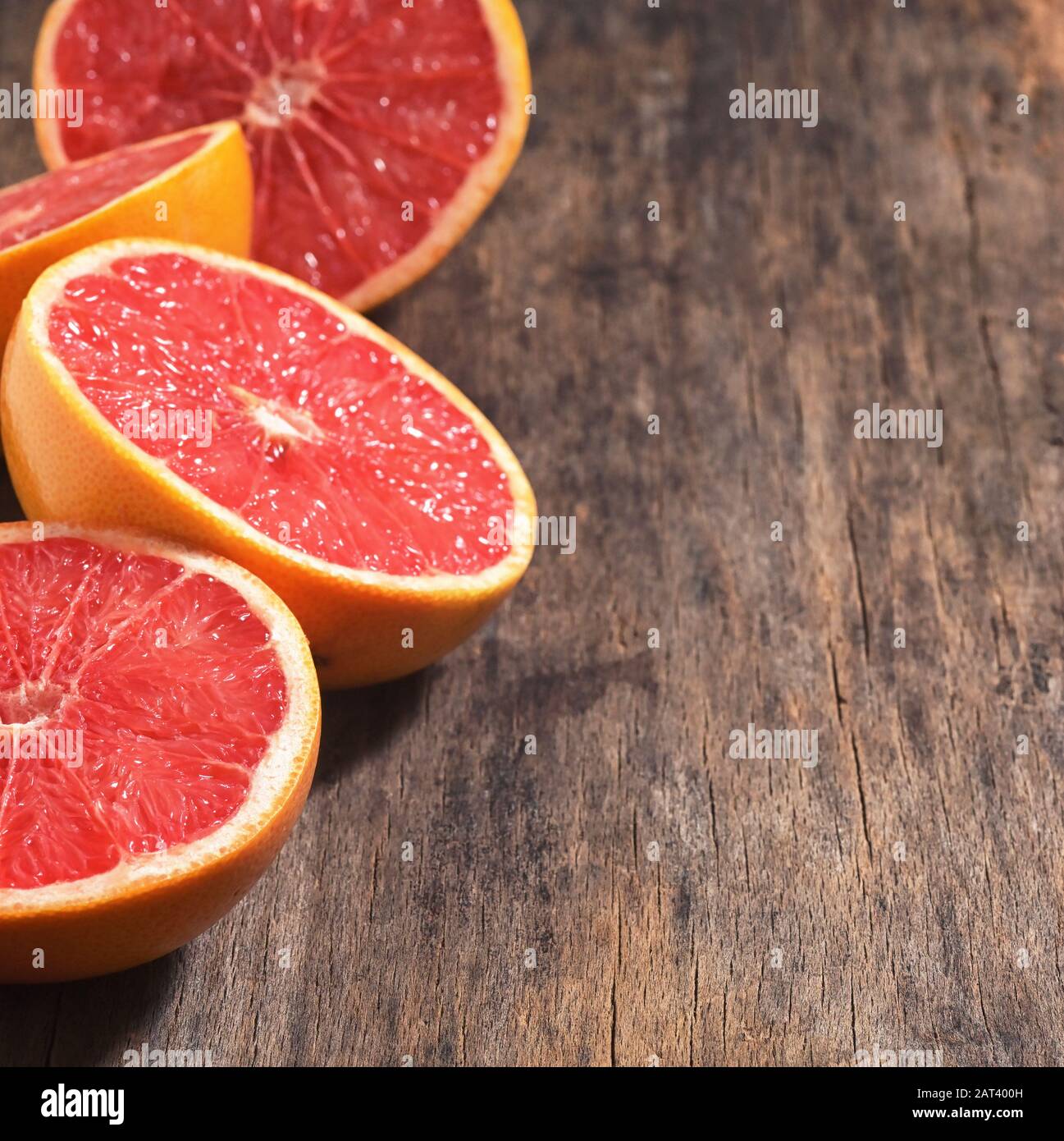 Sliced Red Ripe Grapefruits On Wooden Table Stock Photo