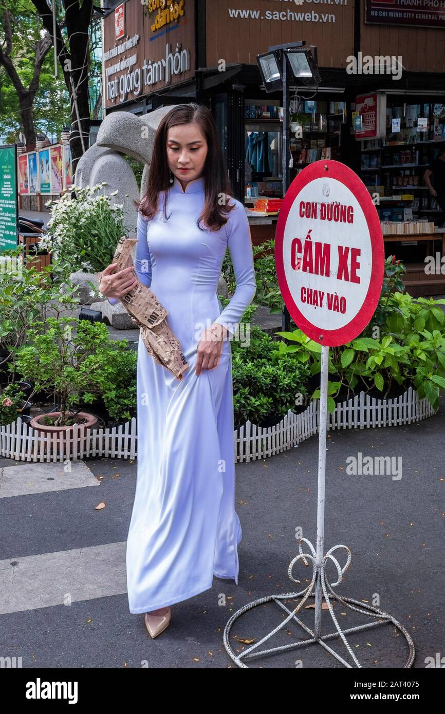 Young woman carrying bunch of flowers in the street, Ho Chi Minh City, Vietnam Stock Photo