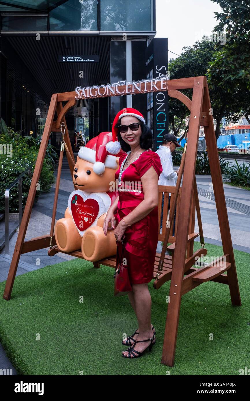 Woman poses for picture with teddy bear during Christmas shopping at the Saigon Centre, Ho Chi Minh City, Vietnam Stock Photo