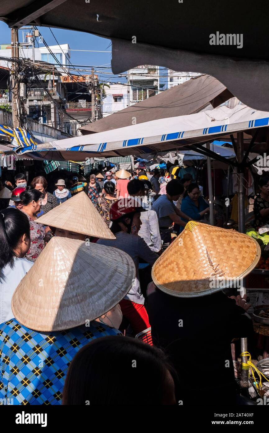 Women wearing conical hat shopping in street market, Ho Chi Minh City, Vietnam Stock Photo
