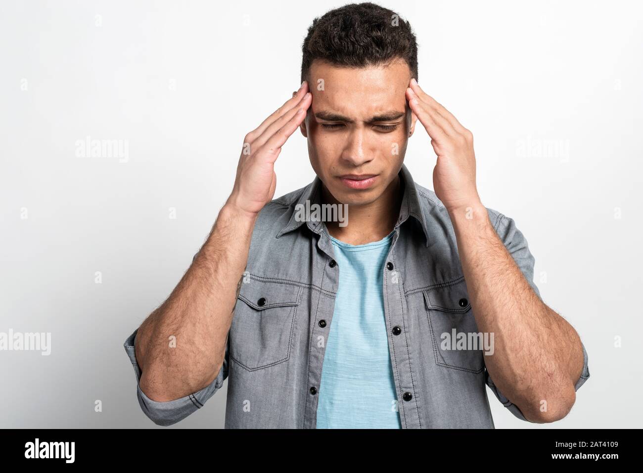 Closeup portrait of a mulatto man holding his head, headache or badly