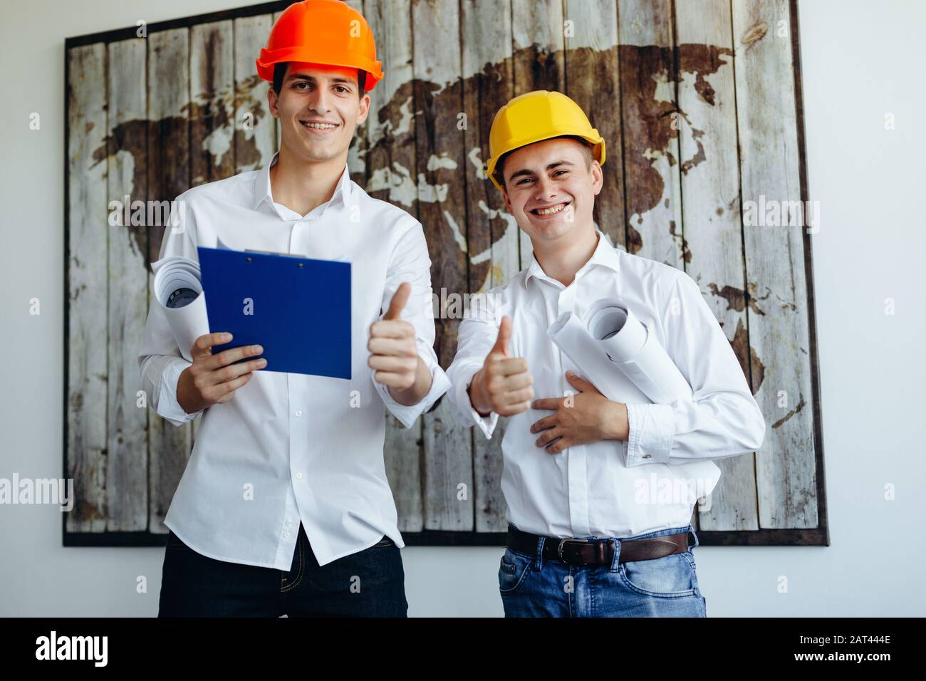 Two young engineers in construction helmets with a tablet and blueprints Stock Photo