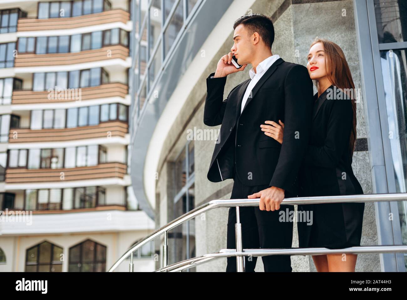 Woman hugging a man who talking a mobile phone. Image Stock Photo Alamy