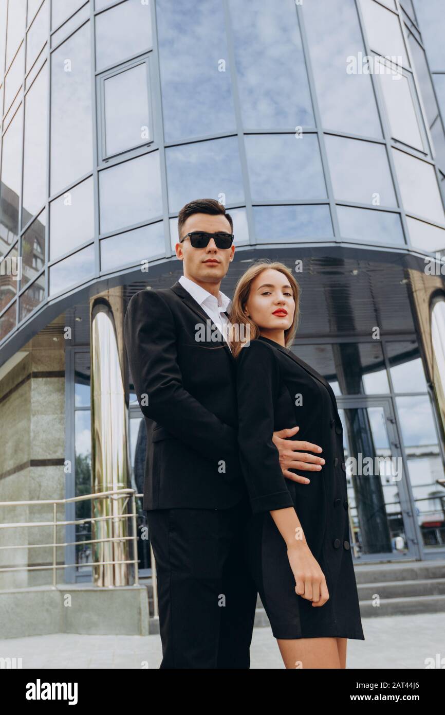 Man in black sunglasses hugging a woman. Romantic couple standing ...