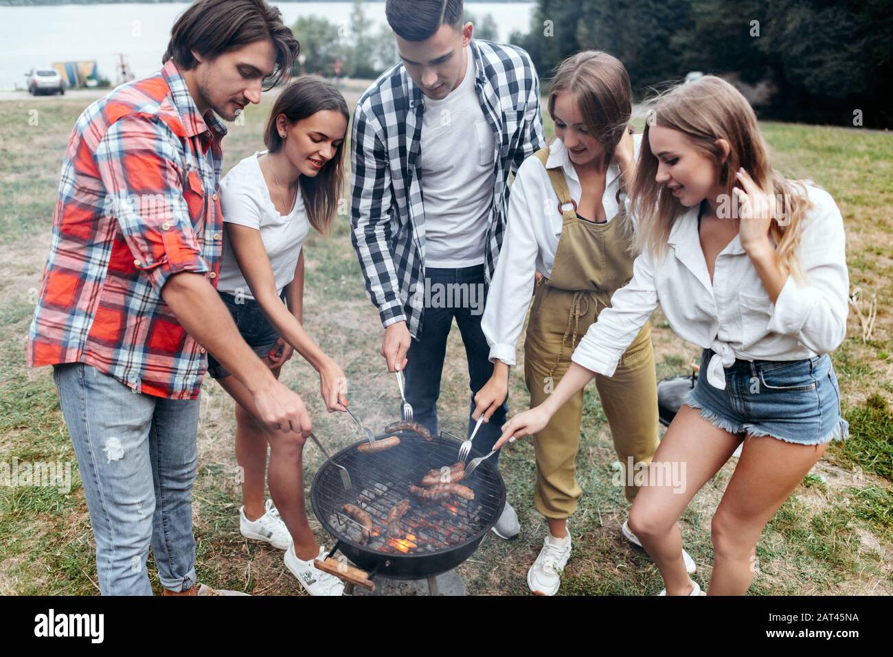 Friends in camp cooking a grill food and  sausages Stock Photo