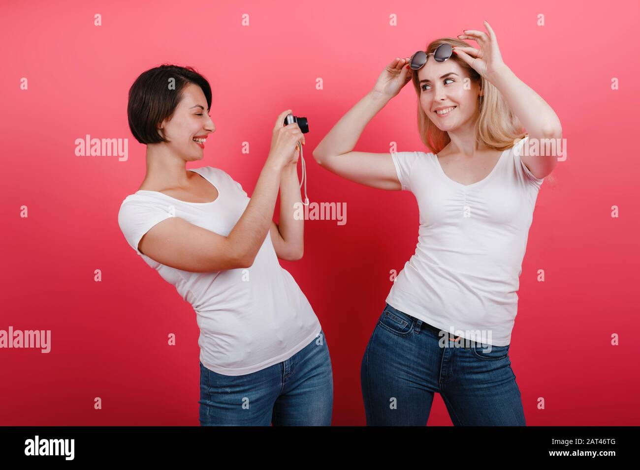 Friendship concept. Happy woman  take a picture her friend holding  photocamera Stock Photo