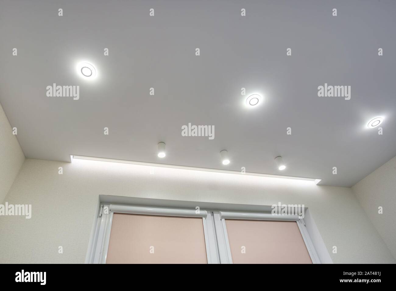 halogen spots lamps on suspended ceiling and drywall construction in in  empty room in apartment or house. Stretch ceiling white and complex shape  Stock Photo - Alamy
