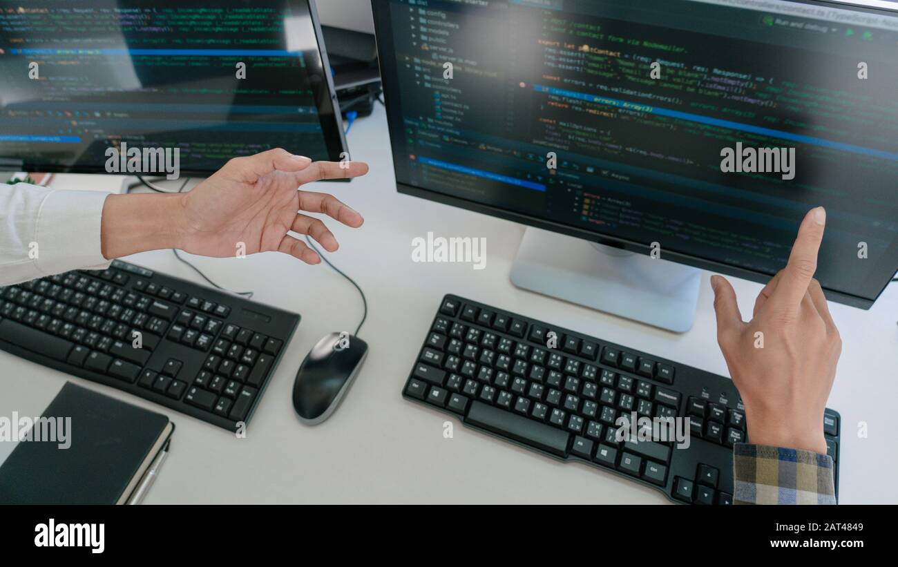 Young startup Programmers Sitting At Desks Working On Computers screen for Developing programming and coding to find solution to problem on New Applic Stock Photo