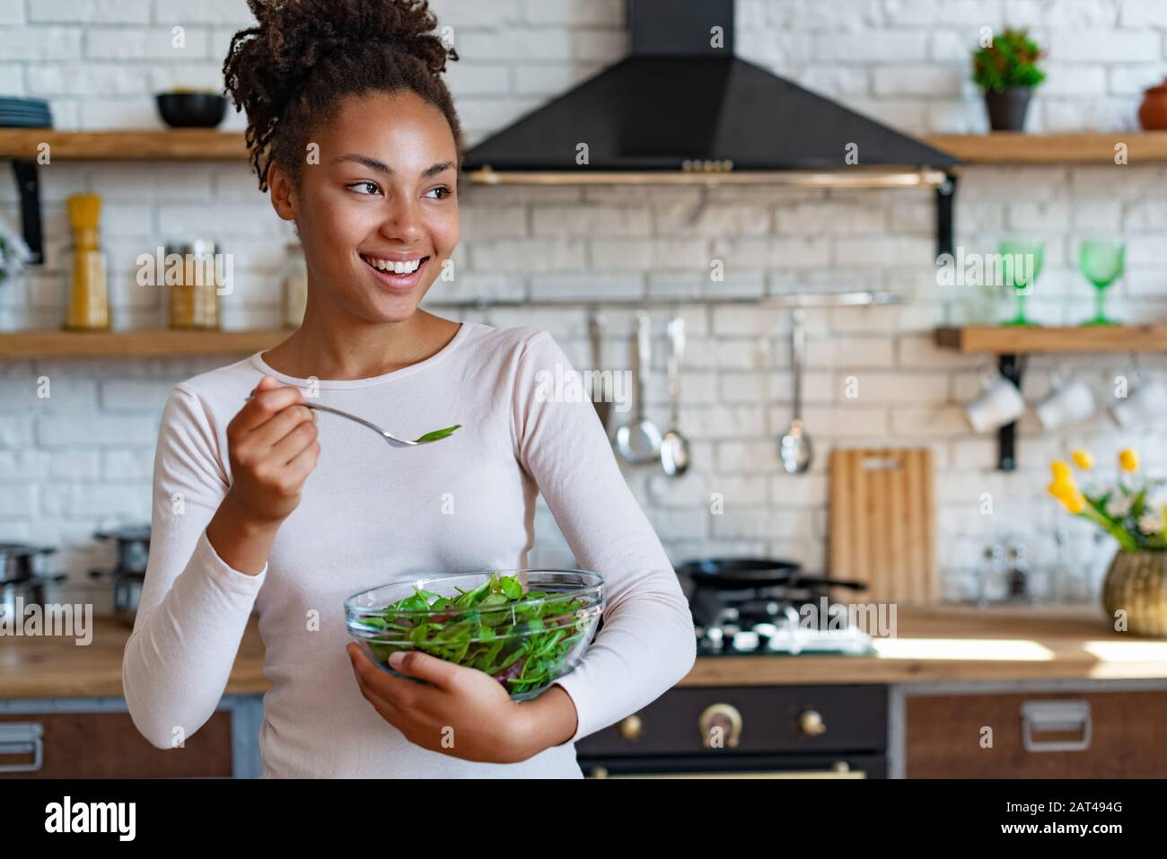 Pretty mulatto household cooking at home a healthy food, tasty a salad - Image Stock Photo