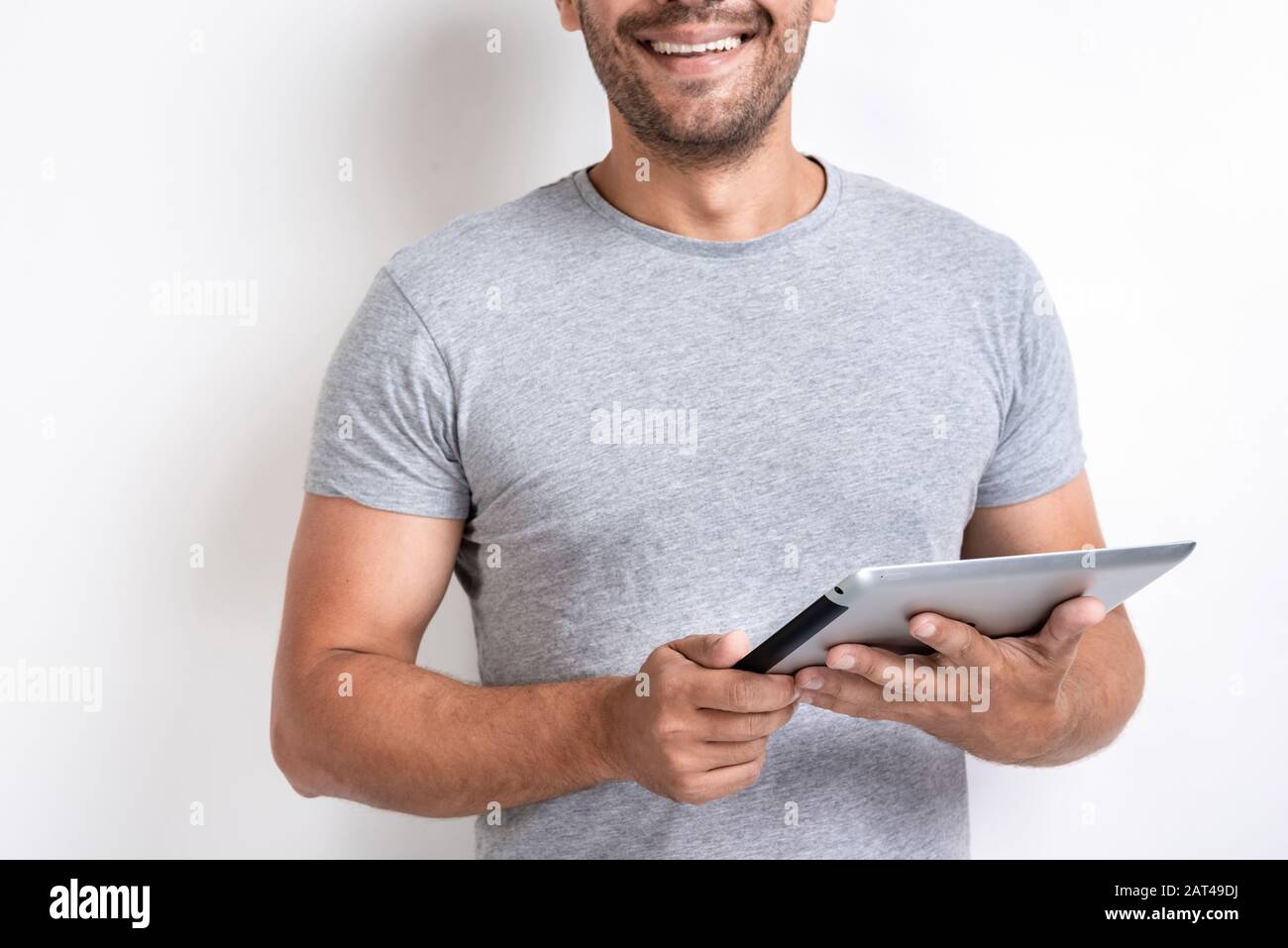 Smiling man holding ipad in his hands. - Cropping image Stock Photo