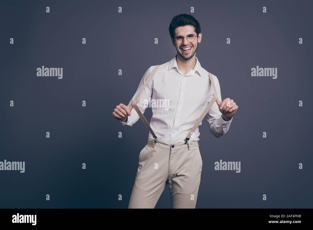 Handsome young businessman pulling his suspenders. Attractive stylish  bearded man in formal wear. Medium shot. White background Stock Photo -  Alamy
