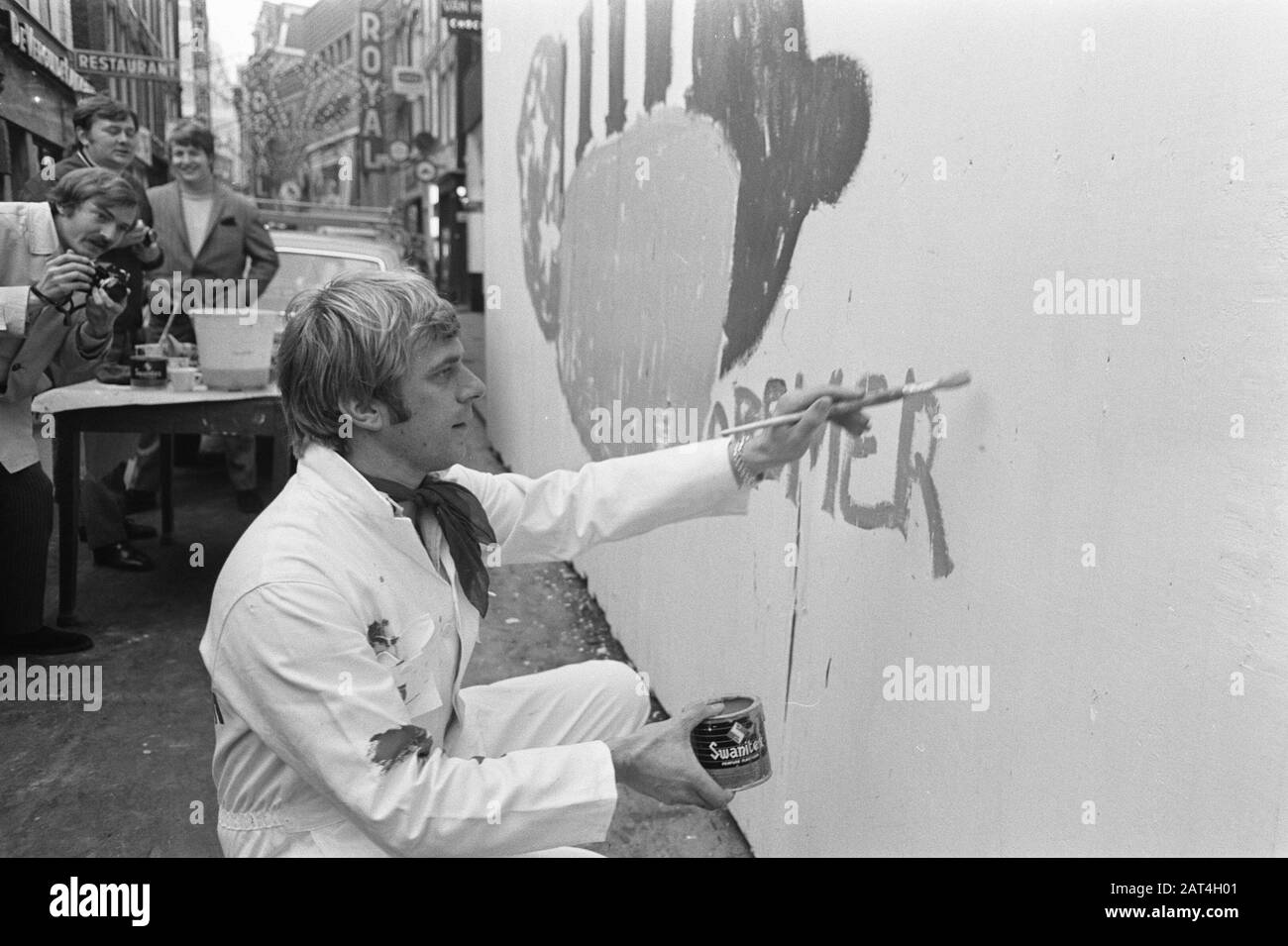 Jan Cremer paints fence on the Nieuwendijk in Amsterdam. Issue 3 J. Cremer, numbers 4.5 Jan Cremer left Lex Daniels (fashion designer) Date: 7 November 1969 Location: Amsterdam, Noord-Holland Personal name: Cremer, Jan, Daniels, Lex Stock Photo