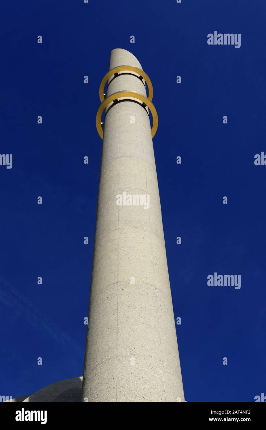 minaret of the cologne mosque with the two golden rings in front of bright blue sky Stock Photo