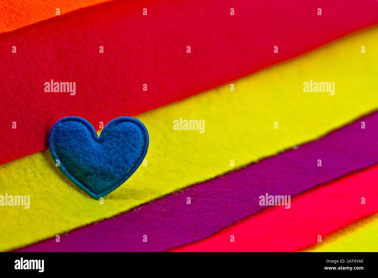 Blue heart on multicolored felt background Stock Photo