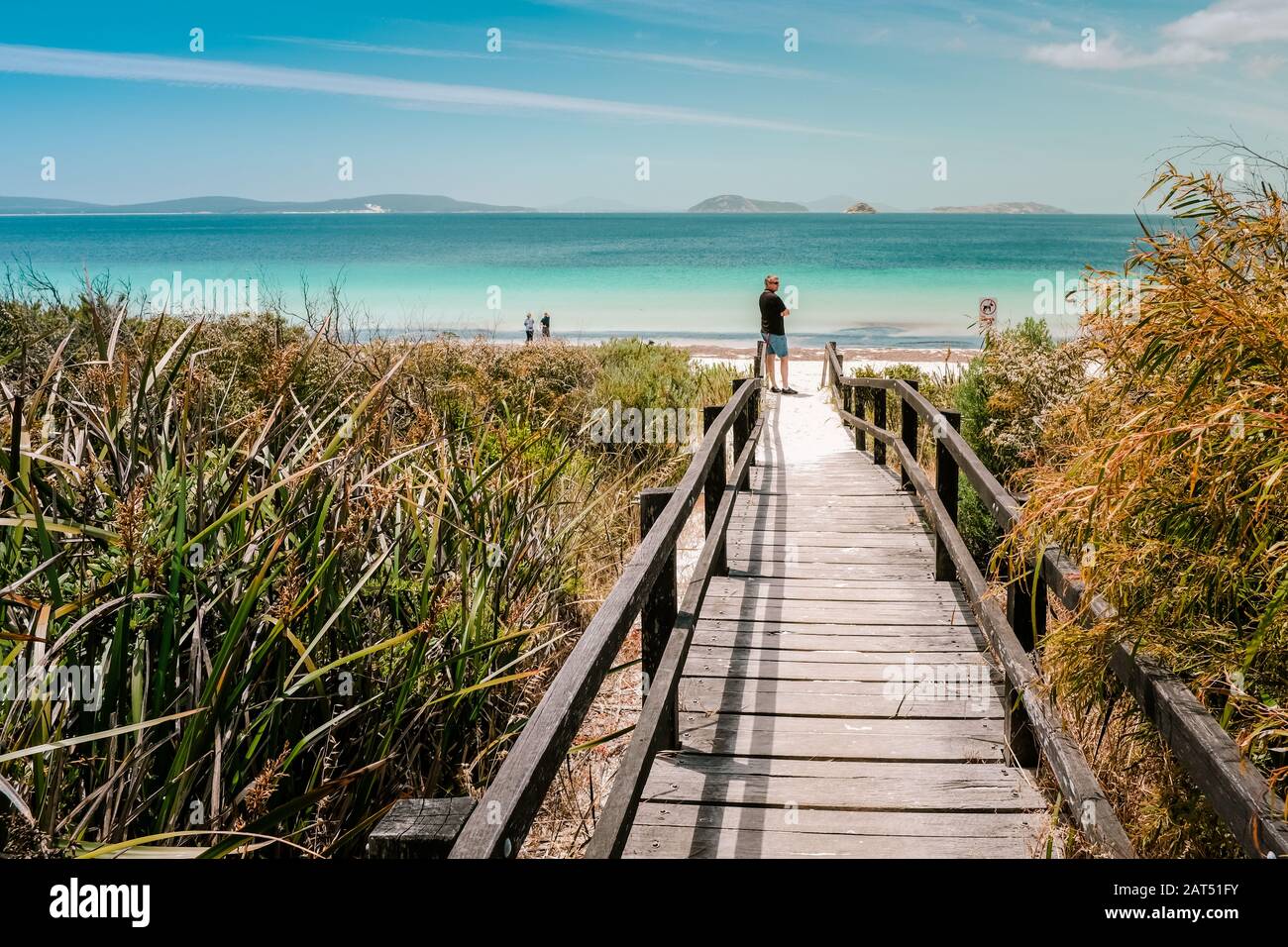 Adult Male Tourist On Wooden Walkway Admires View At Goode Beach