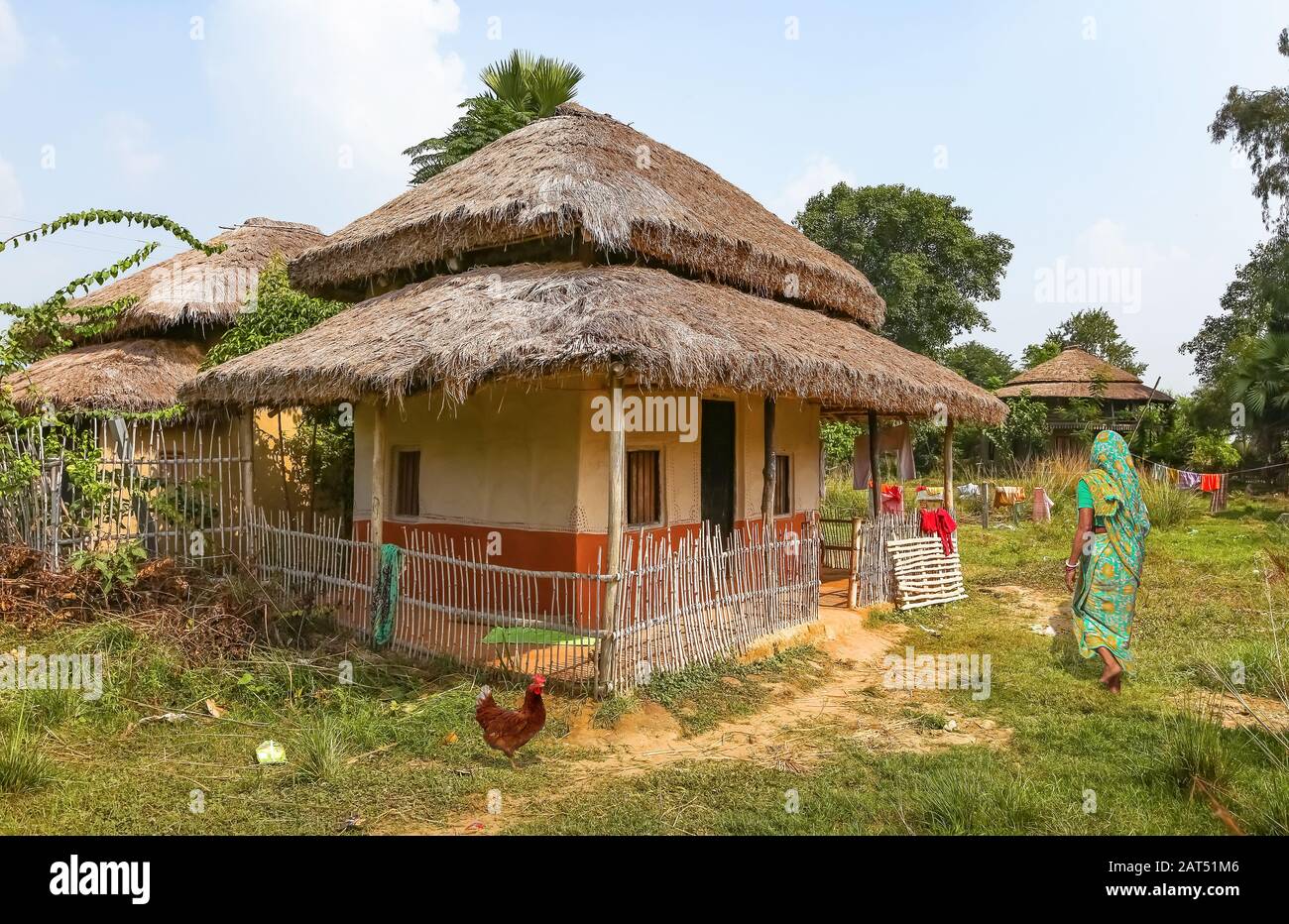 Rural Indian woman near her mud hut with beautiful village scene near Bolpur West Bengal, India Stock Photo