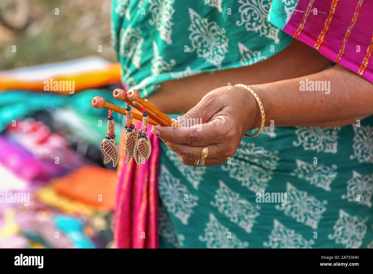 Woman hand selling hand made hair clips at a handicraft fare at Shantiniketan, West Bengal. Photograph shot with selective focus Stock Photo