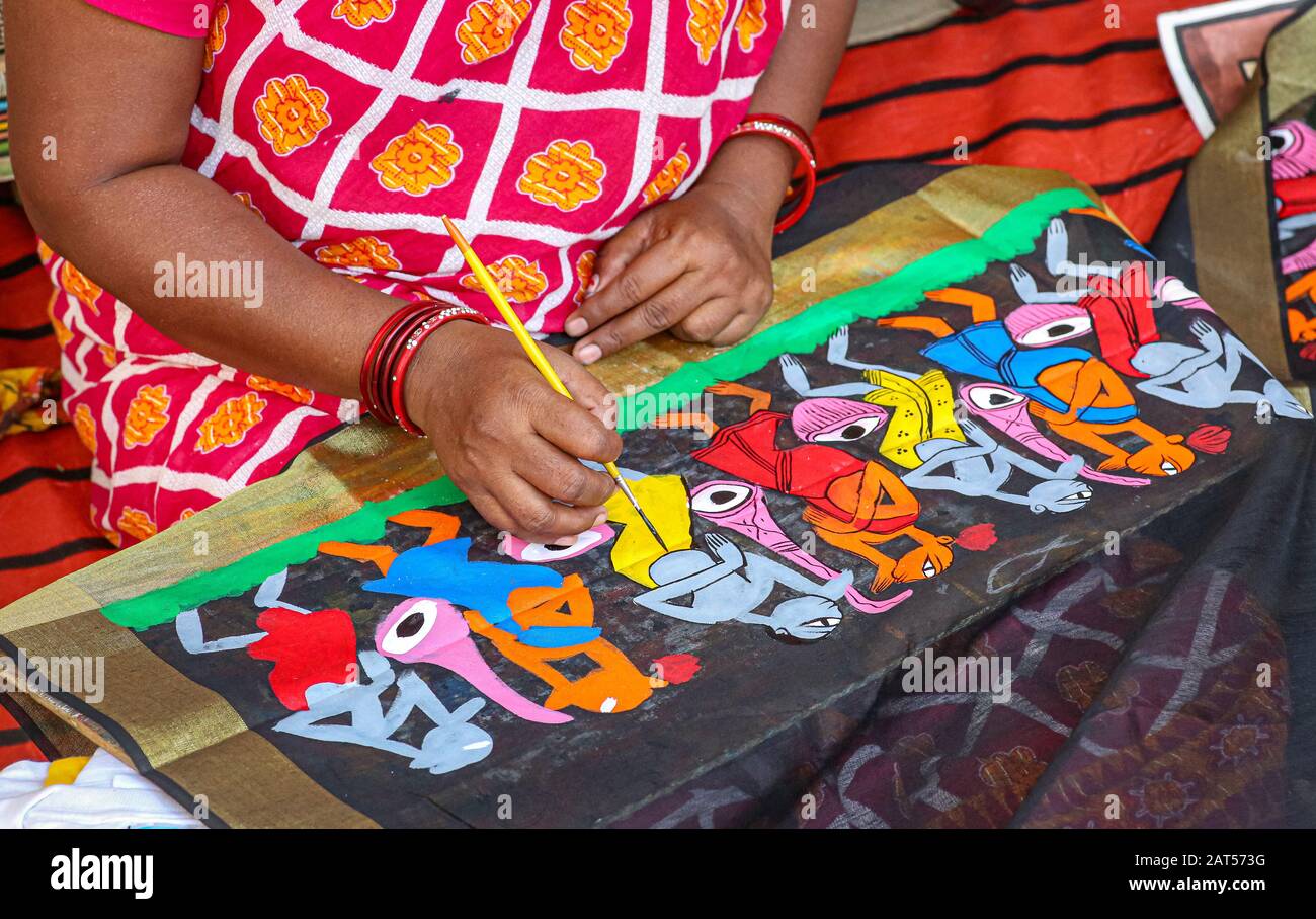 Indian woman artist worker doing fabric painting with brush on a ...