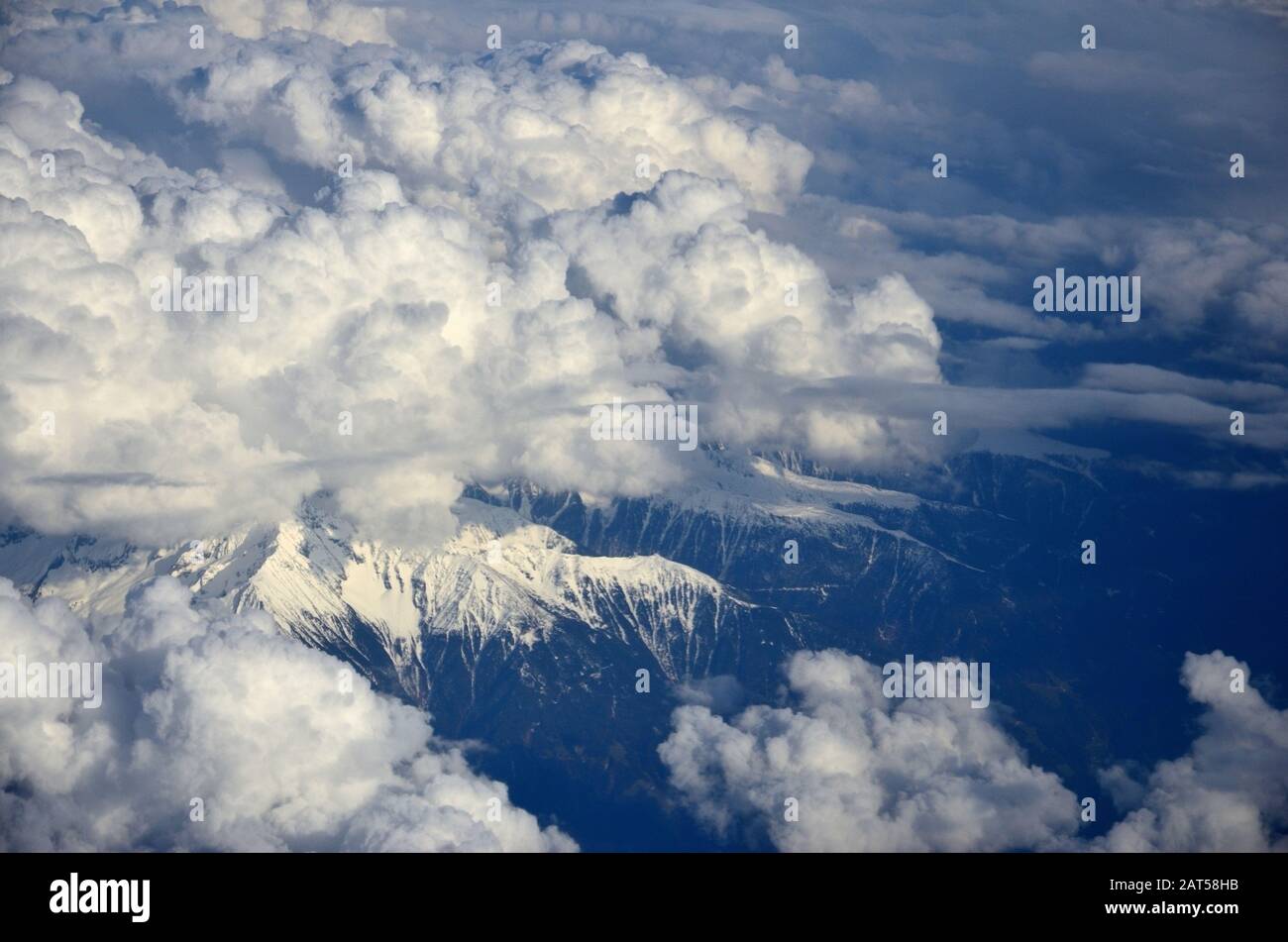 High cloud formations on snow-capped mountains Stock Photo