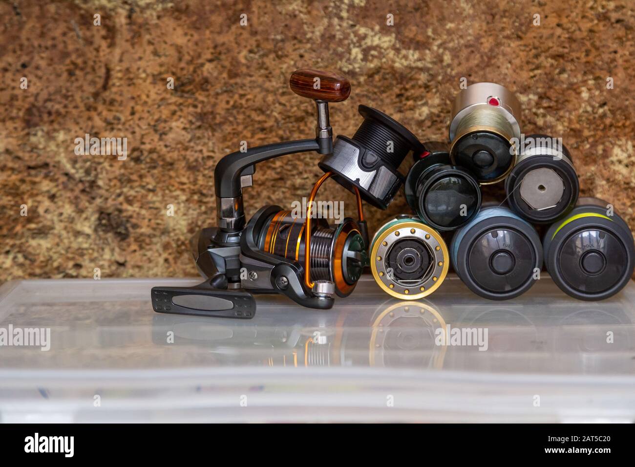 Different fishing tackles, lines and reel on wooden cork background