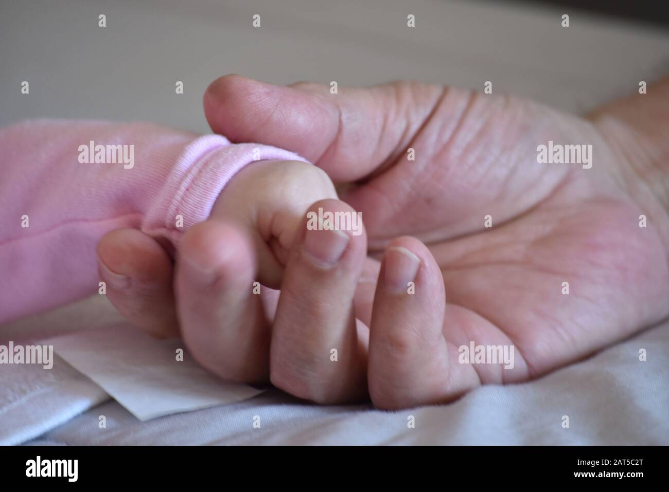 Manos de un bebé y abuelo Stock Photo