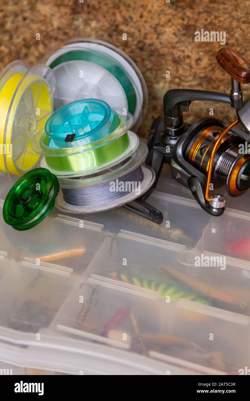 Different fishing tackles, lines and reel on wooden cork background