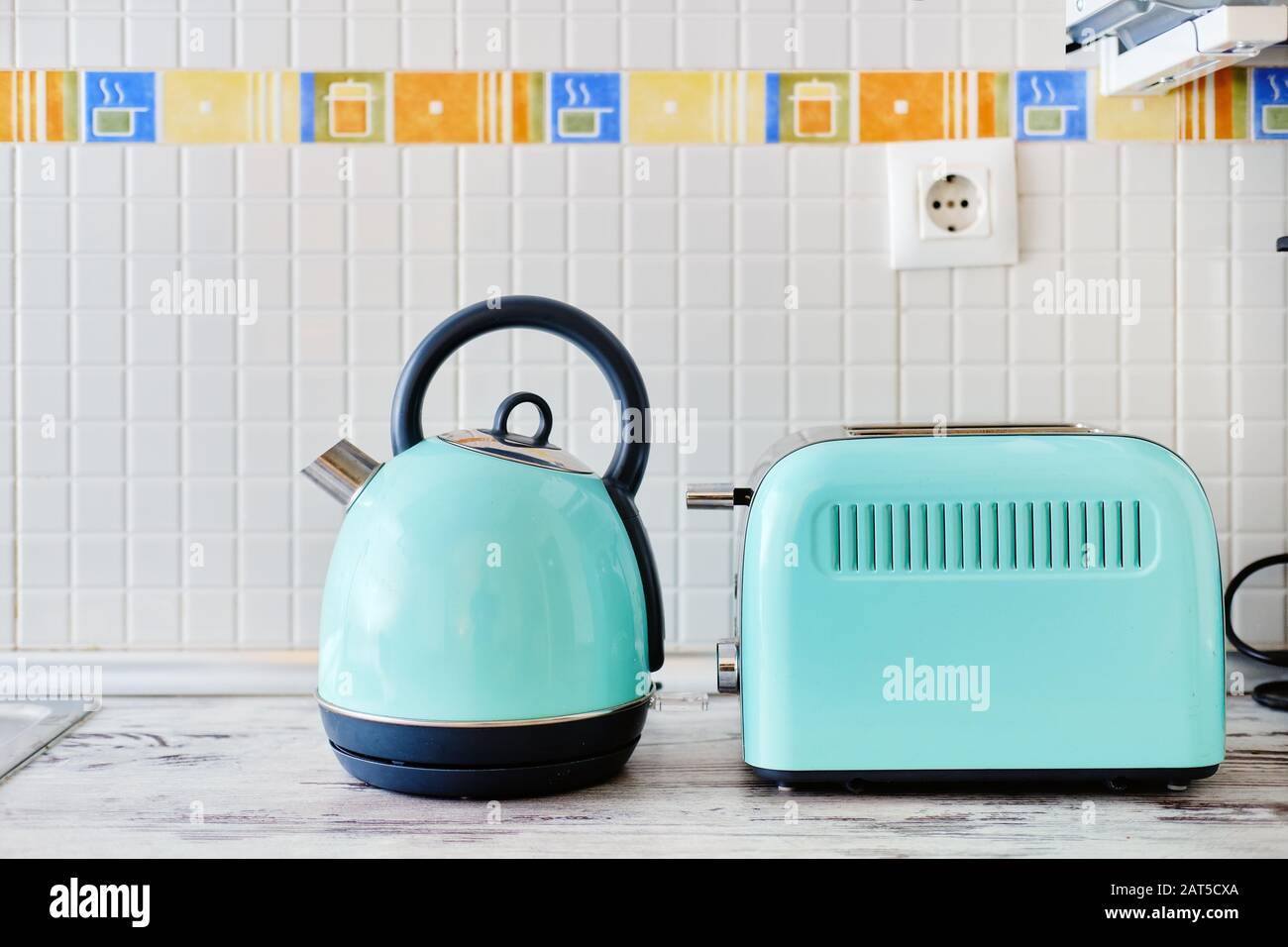 Close up view on work top two objects set, toaster electrical device for making toast and electric kettle electrical modern appliances menthol color Stock Photo