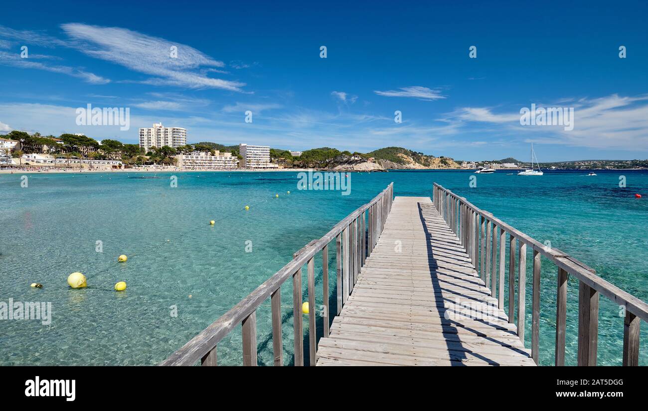 Empty wooden boardwalk leading to Mediterranean Sea clear green lagoon bay waters, freedom, vacation, Palma de Majorca, Spain Stock Photo