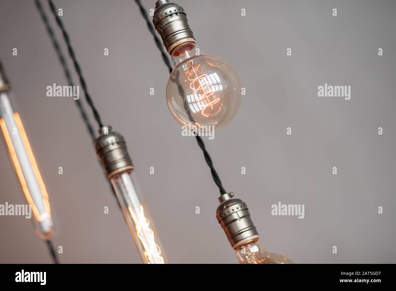 Edison retro lamp incandescent bulbs on gray plaster wall background in loft. Concept Vintage style. Copy space Stock Photo