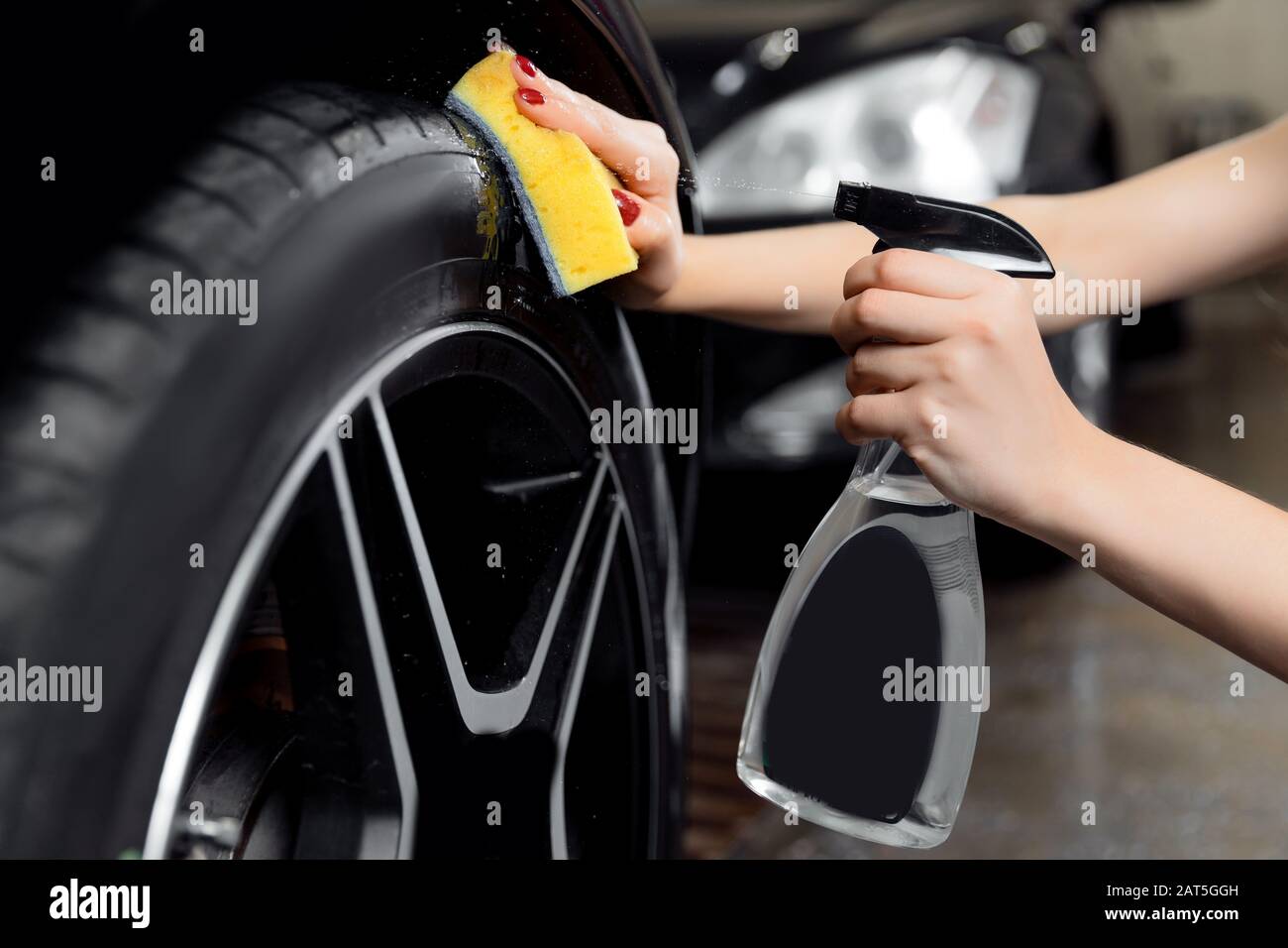 Car wash service, detailing using spray and sponge to wipe black tire Stock Photo Alamy