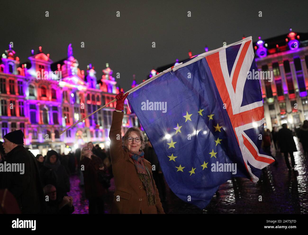 Deirdre Thomas, a resident of Belguim, waving an EU flag and a Union jack in Grand Place in Brussels, Belgium, during a celebration and farewell to the UK on the eve of Brexit. Stock Photo