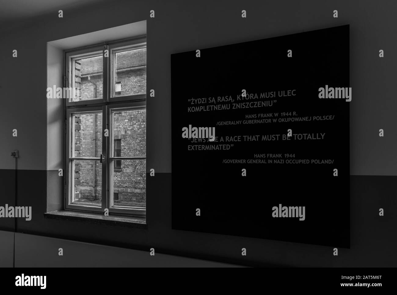 A black and white picture of an exhibit inside the Auschwitz I Museum that shows a disturbing quote. Stock Photo