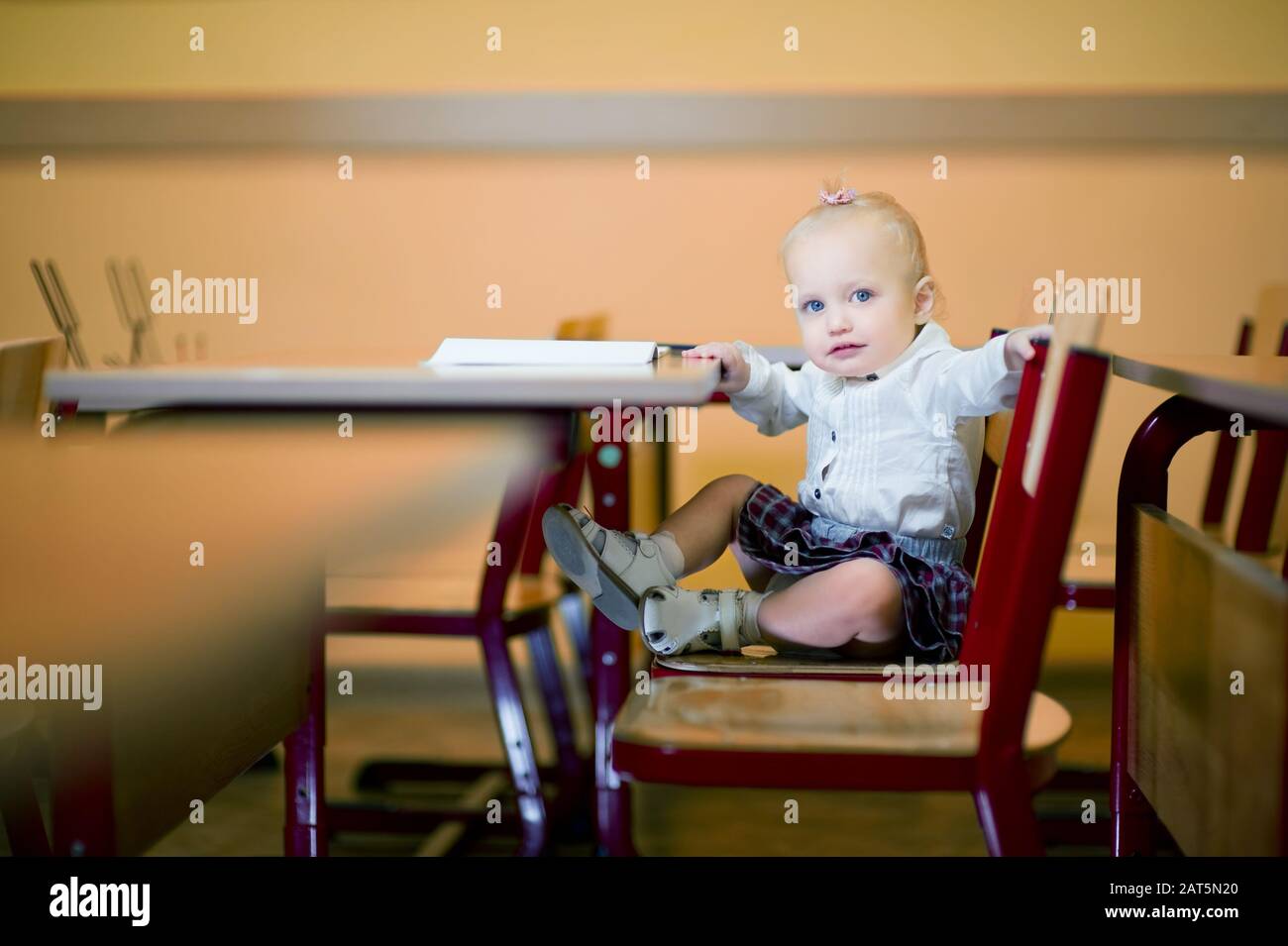 Little baby girl sitting at her desk at school Stock Photo - Alamy