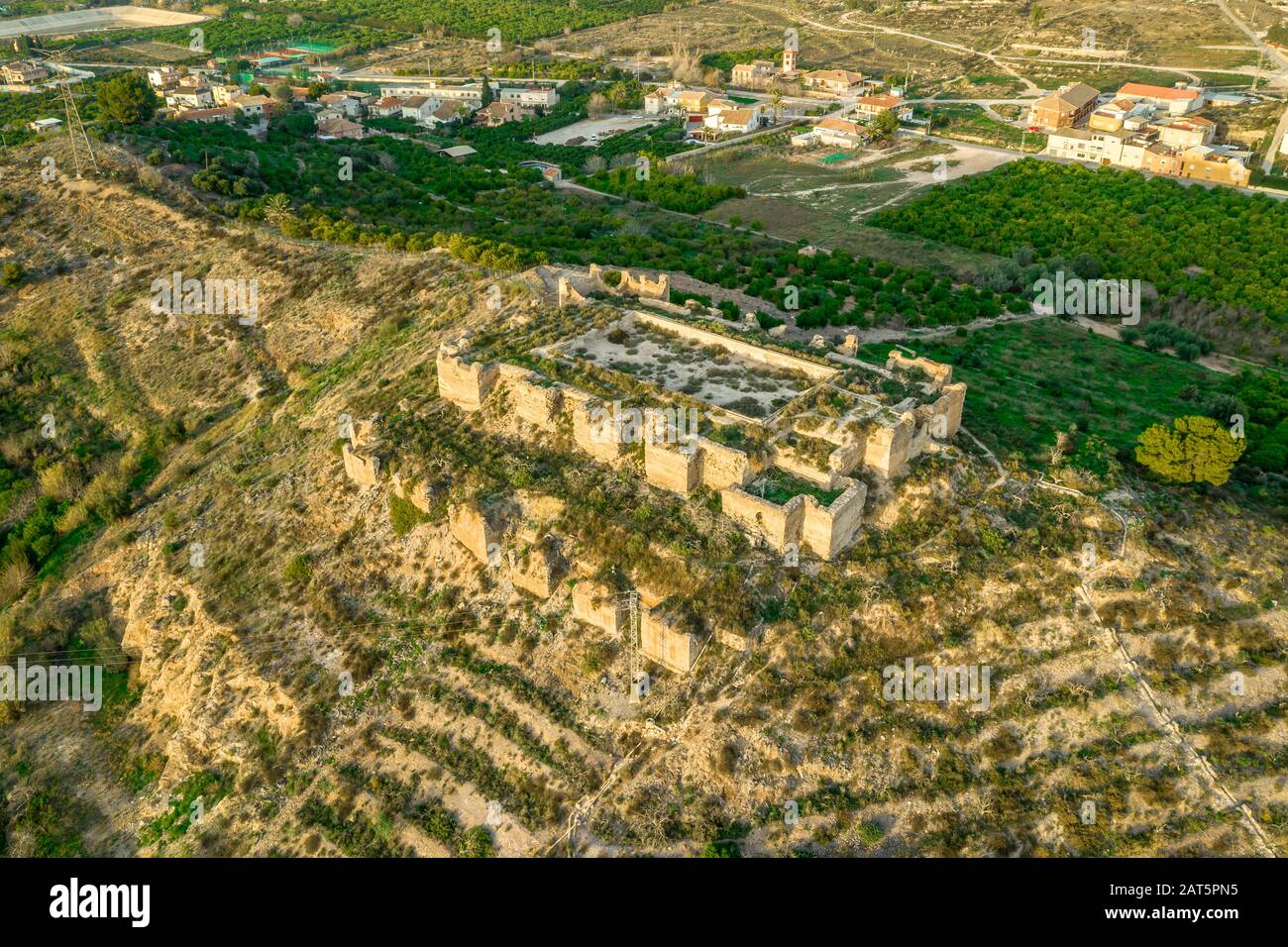 Monteagudo medieval castle ruin twelve rectangular towers circling the hilltop and the sacred heart of Jesus Christ statue on top near Murcia Spain Stock Photo