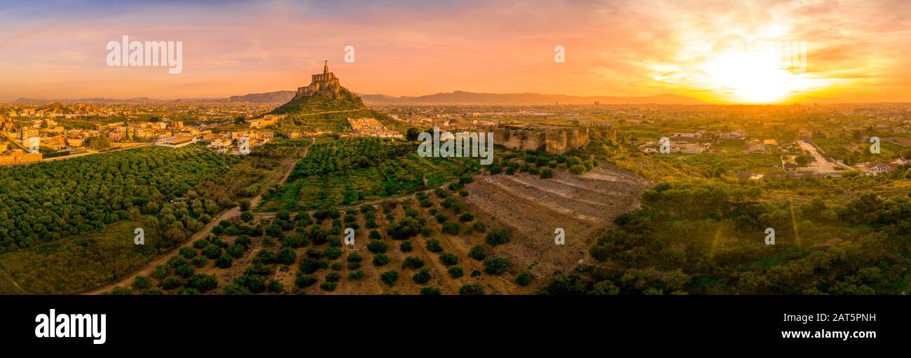 Monteagudo medieval castle ruin twelve rectangular towers circling the hilltop and the sacred heart of Jesus Christ statue on top near Murcia Spain Stock Photo